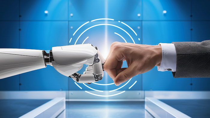 eine Roboterhand und eine menschliche Hand begrüßen sich