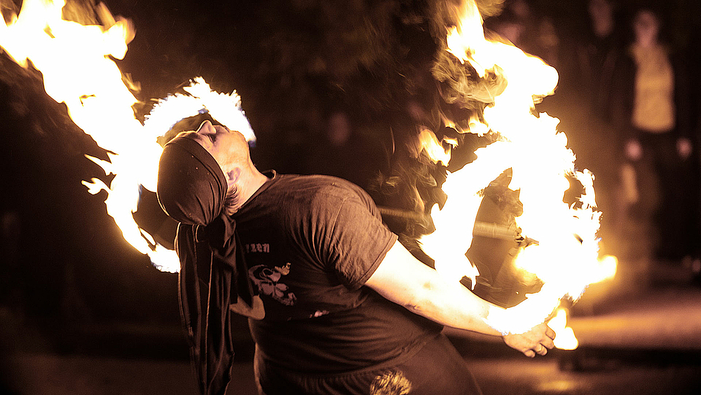 Eine Frau jongliert mit Feuerfackeln.