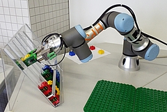 Roboterarm, der Lego-Steine in ein Regal stellt