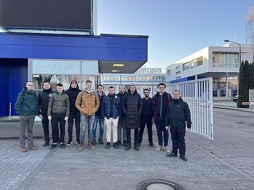 Gruppe steht vor dem Eingangstor von Niles Simmons