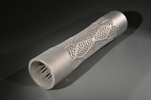 Der Staffelstab der Veranstaltung, der jeweils an den nachfolgenden Gastgeber übergeben wird, wurde am Laserinstitut Hochschule Mittweida mittels selektivem Laserschmelzen (SLM), ein Verfahren im additiven Metalldruck, hergestellt. Foto eines Metallstabes mit einem Durchbruchsmuster