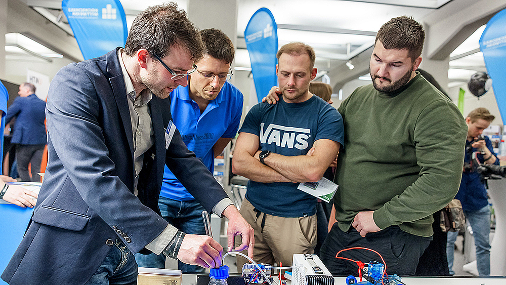 Johannes Näther führte das SPIN2030-Publikum mit einem Demonstrator an seine Forschung heran: Er beschäftigt sich mit der Katalyse von grünem Wasserstoff - inklusive Knallgasprobe. Foto: SMWK | Ben Gierig