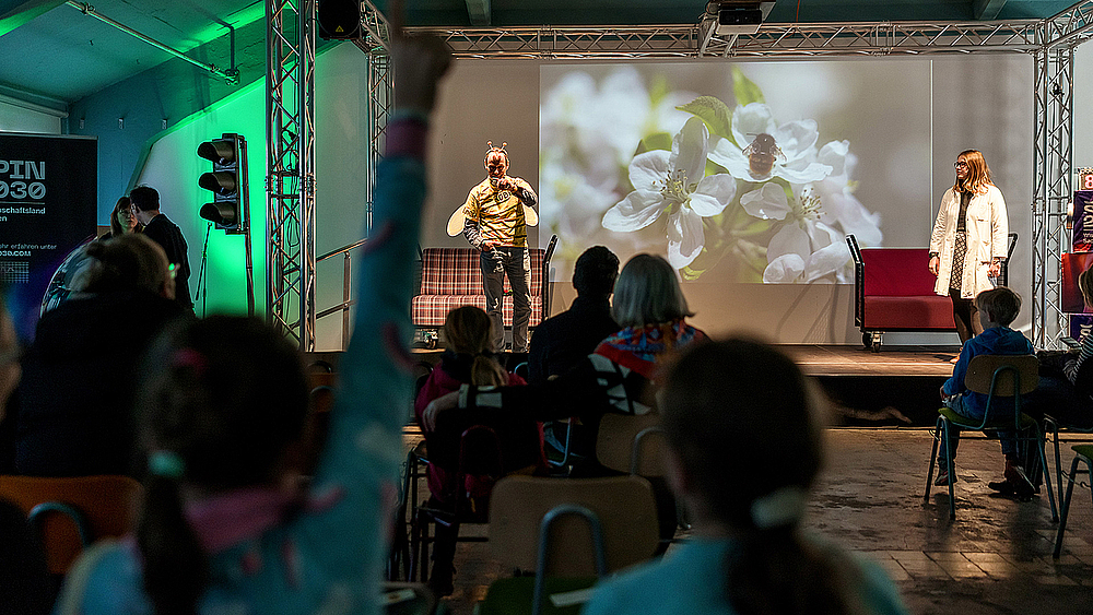 Professor Röbbe Wünschiers (Biene) und Lisa Prudnikow (Laborkittel) führten die wissbegierigen Kinder an die Bedeutung der Biodiversität heran. Foto: SMWK | Ben Gierig