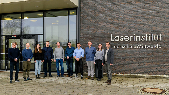 Zehn Personen stehen vor dem Eingang des Laserinstitut Hochschule Mittweida
