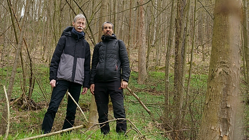 Zwei männliche Personen in einem Waldstück