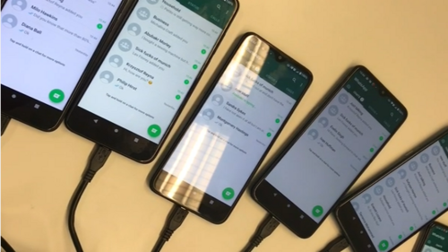 Fünf Smartphones am Ladekabel mit geöffneten Chats